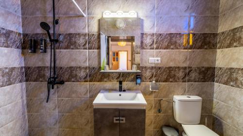 a bathroom with a sink and a toilet and a mirror at Riad Ghazal in Essaouira