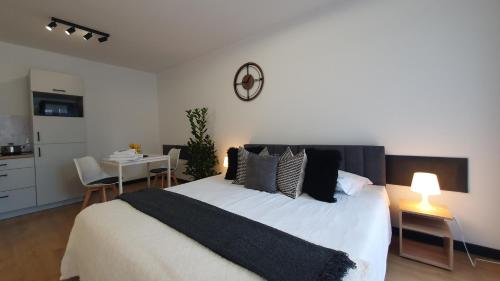 a bedroom with a large white bed and a table at VESTA Apartamenty M52 Free parking in Szczecin