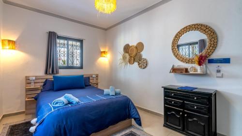 a bedroom with a blue bed and a dresser at Riad Ghazal in Essaouira
