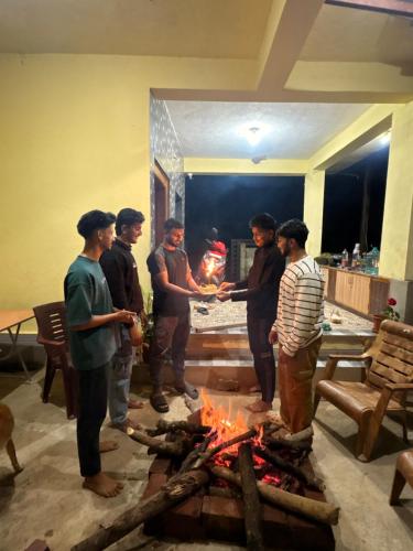 a group of people standing around a fire at Swasthiks Home stay in Sakleshpur