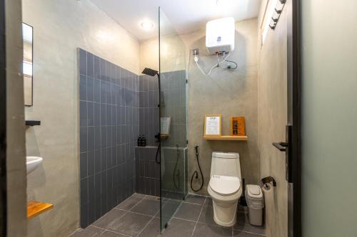 a bathroom with a toilet and a glass shower at SNUG Kuta in Kuta