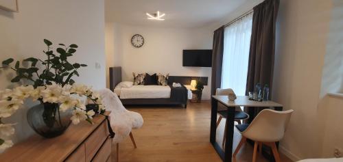 a living room with a bed and a vase of flowers at VESTA Apartamenty M52 Free parking in Szczecin