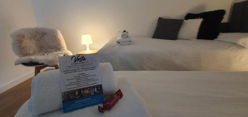 a room with a bed with a sign and a chair at VESTA Apartamenty M52 Free parking in Szczecin
