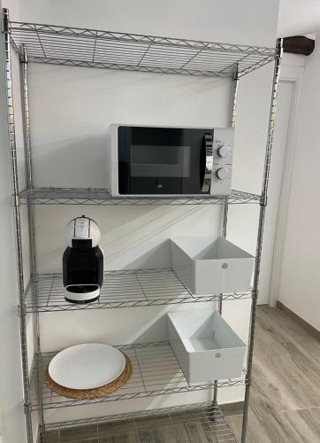 a shelf with a microwave and a toilet in a room at Villa Rosa in Jerez del Marquesado