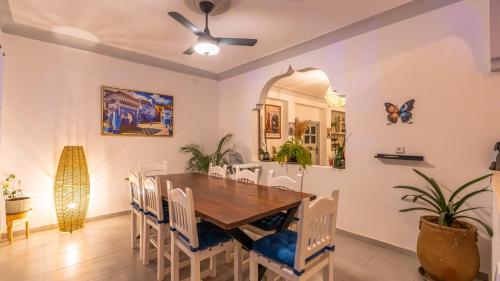 a dining room with a wooden table and chairs at Riad Ghazal in Essaouira