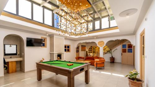 a living room with a pool table and a chandelier at Riad Ghazal in Essaouira