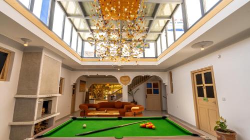 a living room with a pool table and a chandelier at Riad Ghazal in Essaouira