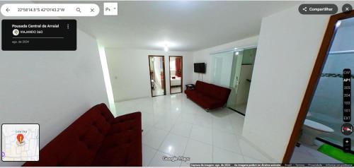 a living room with a red couch in a room at Pousada Central de Arraial in Arraial do Cabo