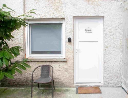 a chair sitting in front of a building with a door at Private Secluded Studio in Sesvete