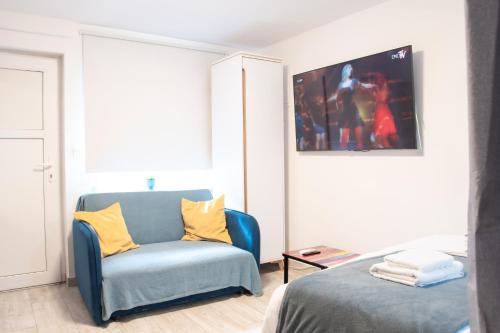 a bedroom with a blue chair and a bed at Private Secluded Studio in Sesvete