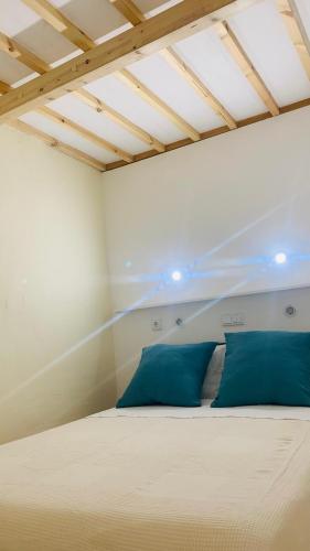 a bedroom with a large bed with blue pillows at Alma d'Corval in Aldeia do Mato