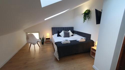 a bedroom with a bed and a chair in it at VESTA Apartamenty M52 Free parking in Szczecin