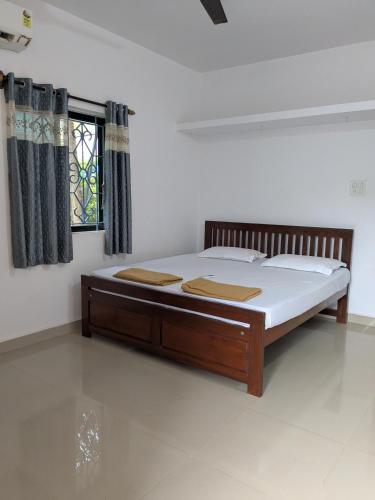 Un dormitorio con una cama en una habitación con ventana. en Shivkrupa Apartments, en Arambol