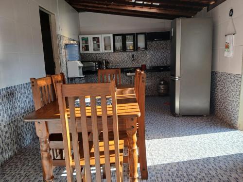 a kitchen with a wooden table and a refrigerator at Furtado Temporada in Santo Amaro