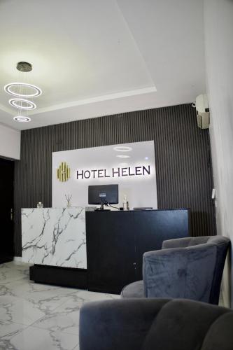 Un vestíbulo de hotel en Helenstain con sillas y un mostrador de recepción. en Hotel Helen, en Ilado