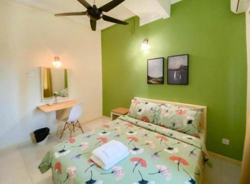 a bedroom with green walls and a bed and a desk at Aurora Court Service Apartment in George Town
