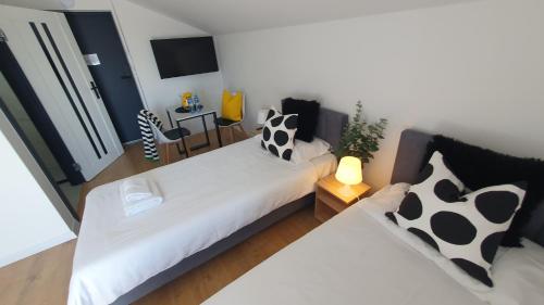 a bedroom with a white bed with black and white pillows at VESTA Apartamenty M52 Free parking in Szczecin