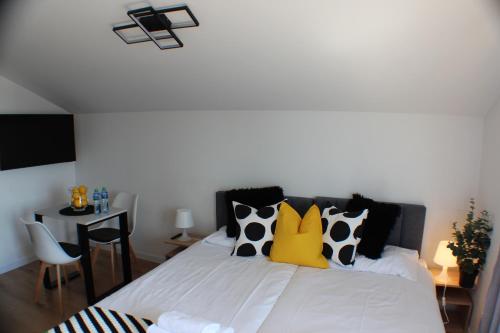 a bedroom with a white bed with black and yellow pillows at VESTA Apartamenty M52 Free parking in Szczecin