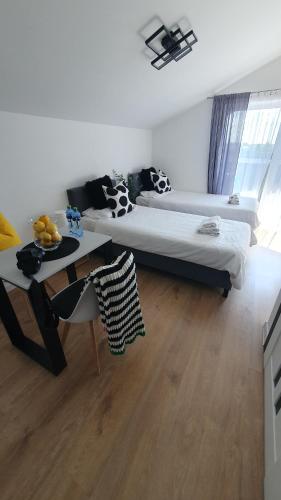 a bedroom with two beds and a table in it at VESTA Apartamenty M52 Free parking in Szczecin