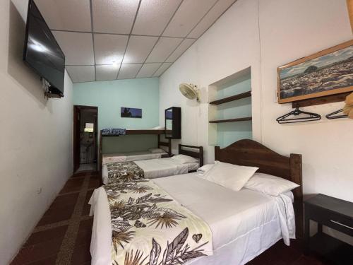 a room with two beds and a flat screen tv at Finca Santa Helena in Restrepo