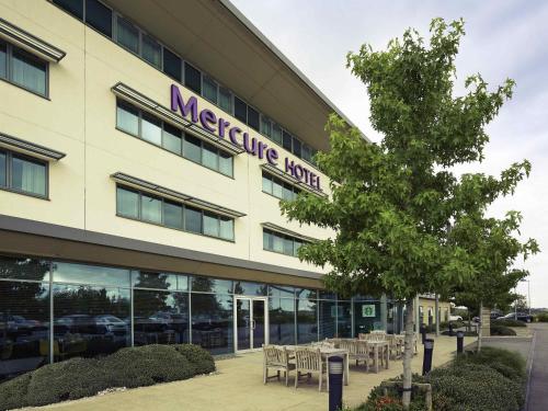 a large building with tables and chairs in front of it at Mercure Sheffield Parkway in Sheffield