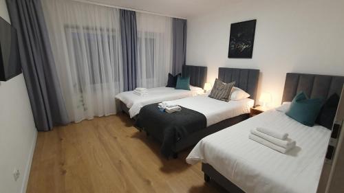 a hotel room with two beds with white sheets at VESTA Apartamenty M52 Free parking in Szczecin