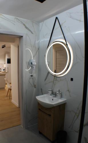 a bathroom with a sink and a mirror at VESTA Apartamenty M52 Free parking in Szczecin