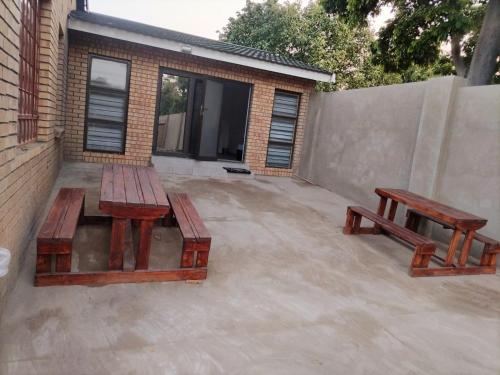 two picnic tables and benches on a patio at C-Rane Lodge - E in Phalaborwa
