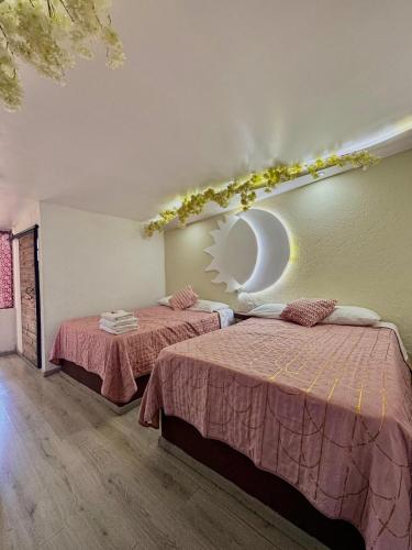 a room with two beds and a mirror on the wall at Vicalis Hotel, Villas y Glamping in San Sebastian Xolalpa