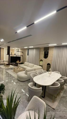 a living room with couches and a table and chairs at Love Residence Al Arid in Riyadh