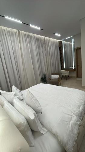 a bedroom with a white bed with white pillows at Love Residence Al Arid in Riyadh