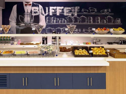 a buffet line with various food items on a counter at ibis budget BH Afonso Pena Savassi in Belo Horizonte