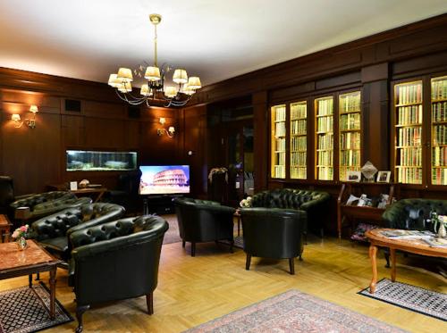 a living room with green chairs and a television at Grand Hotel Residence Piešťany - Boutique hotel in Piešťany