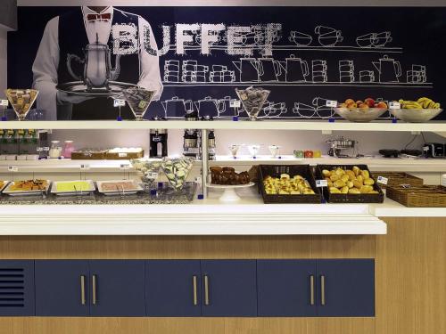 a buffet line with various food items on display at ibis budget BH Afonso Pena Savassi in Belo Horizonte