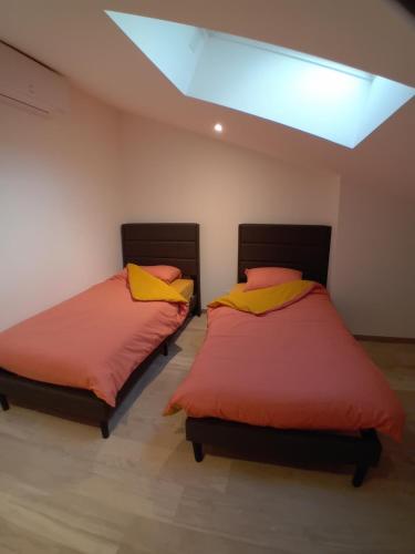 two beds in a room with a skylight at Gite de la Mouline in Lectoure