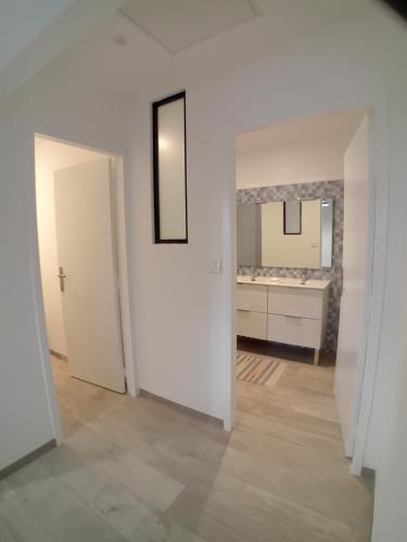 an empty white room with a mirror and a bathroom at Gite de la Mouline in Lectoure
