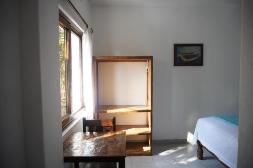 a bedroom with a bed and a desk and a window at Akumal Hotel in Máncora