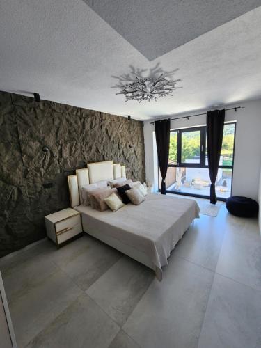ein Schlafzimmer mit einem Bett und einer Steinwand in der Unterkunft La Villa Luxury Home Bihac in Bihać