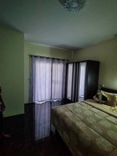 a bedroom with a bed and a window with curtains at Kata Lina guesthouse in Kata Beach