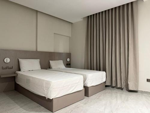 ein Schlafzimmer mit zwei Betten mit weißer Bettwäsche in der Unterkunft Viaje Hotel Downtown Cairo in Kairo