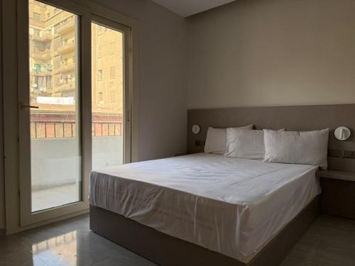 een slaapkamer met een bed met een groot raam bij Viaje Hotel Downtown Cairo in Caïro