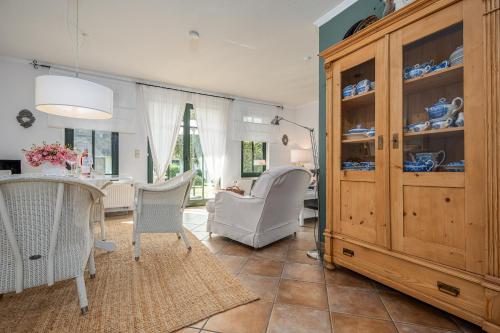 een eetkamer met een tafel en stoelen en een houten kast bij Born - Wieck Ferienwohnung Wildrose in Wieck