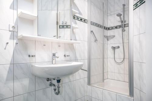 een witte badkamer met een wastafel en een douche bij Born - Wieck Ferienwohnung Wildrose in Wieck