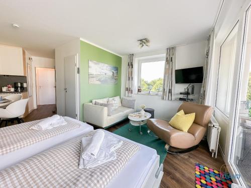 Una habitación de hotel con dos camas y una sala de estar. en Watt n Blick 220, en Döse