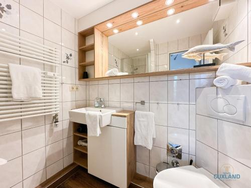 un baño con lavabo y espejo en Watt n Blick 220, en Döse