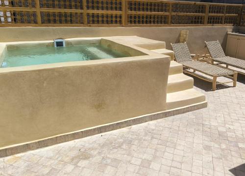 a large pool with two chairs and a table at Riad MAGE Marrakech in Marrakech