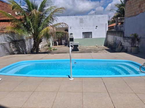 a blue swimming pool in a courtyard with a fountain at Casa AMORA 2 quartos PISCINA in Aparecida