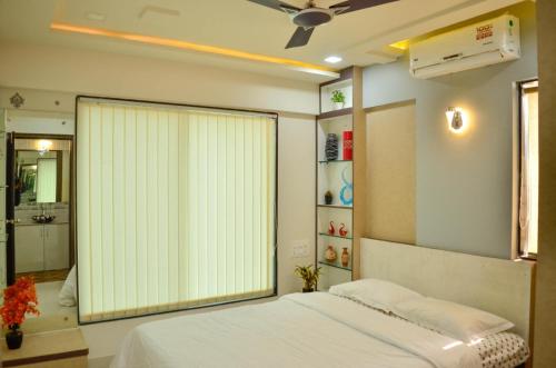ein Schlafzimmer mit einem Bett und einem großen Fenster in der Unterkunft Rk Stay 2bhk Balewadi Highstreet Fully Furnished Premium in Pune