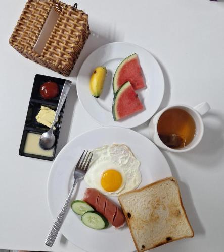 a table with two plates of food with eggs and bread at ADRI Hotel in Phu Quoc