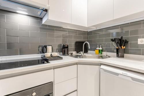 a kitchen with white cabinets and a sink at Chido Residence in Istanbul